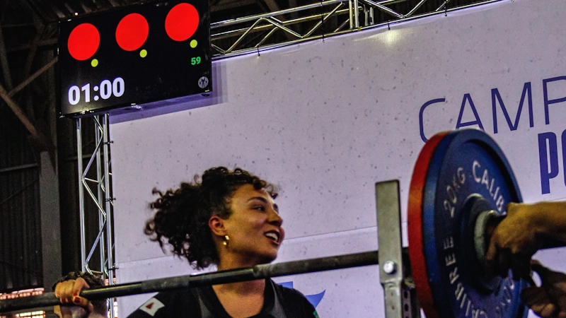 Powerlifter saindo do rack de agachamento com as luzes de arbitragem atrás dela